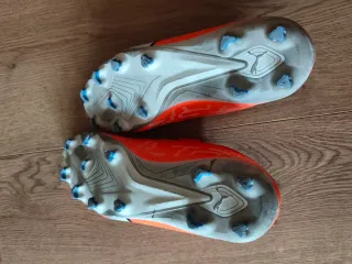 Zapatillas niño tacos de fútbol Puma naranjas.