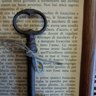 Quadretto con chiave antica e pagina libro