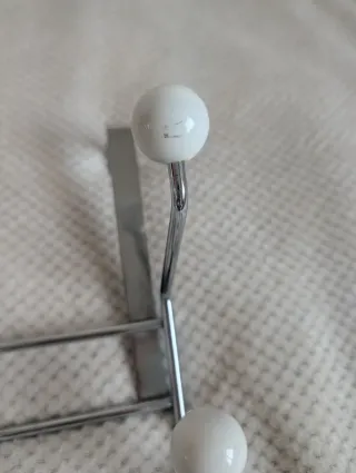 Perchero de puerta plateado con bolas blancas