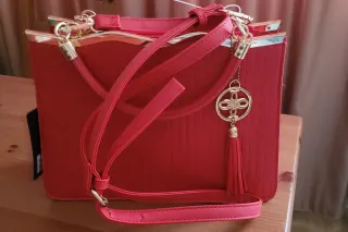 Bolso rojo con detalle dorado.