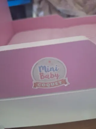 Cuna de juguete rosa y blanca