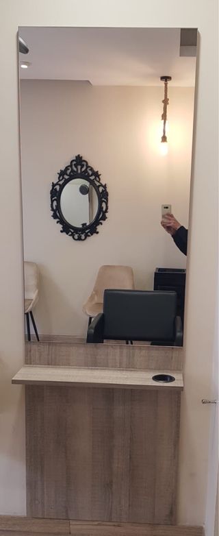 Tocador peluquería con espejo y soporte.
