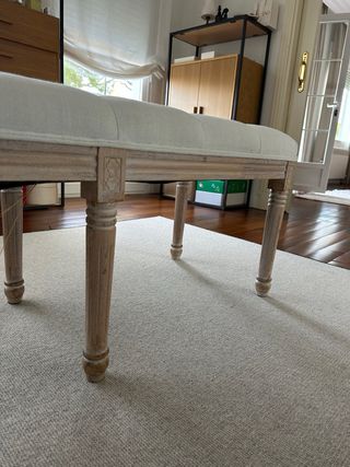 Banco tapizado beige con patas de madera