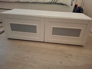 Mueble blanco con cojín beige