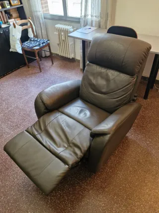 Sillón de piel reclinable con reposapies.