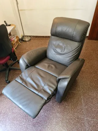 Sillón de piel reclinable con reposapies.
