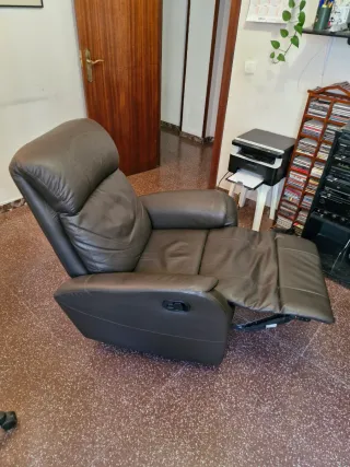 Sillón de piel reclinable con reposapies.