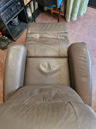 Sillón de piel reclinable con reposapies.