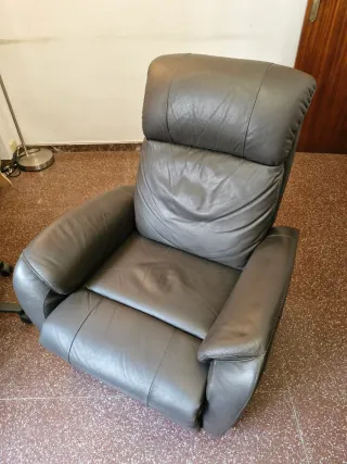 Sillón de piel reclinable con reposapies.