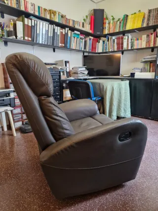 Sillón de piel reclinable con reposapies.