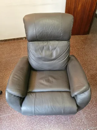 Sillón de piel reclinable con reposapies.