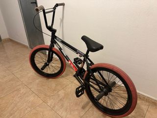 Bicicleta BMX negra con ruedas rosas
