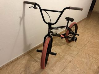 Bicicleta BMX negra con ruedas rosas