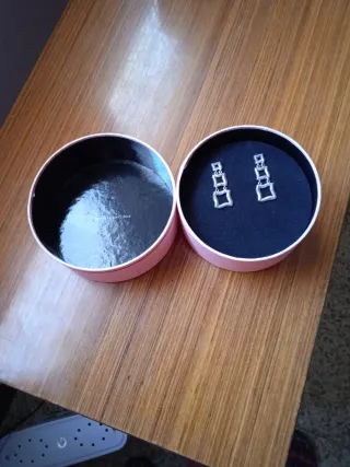 Pendientes largos plateados con diseño cuadrado.