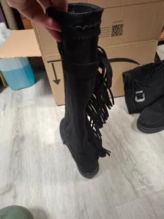 Botas altas negras con flecos y hebilla
