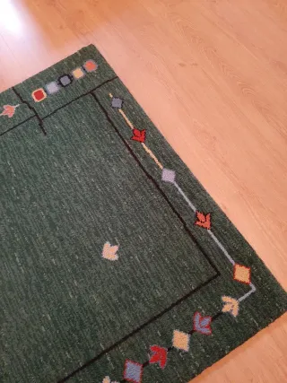 Alfombra de lana verde con diseño multicolor