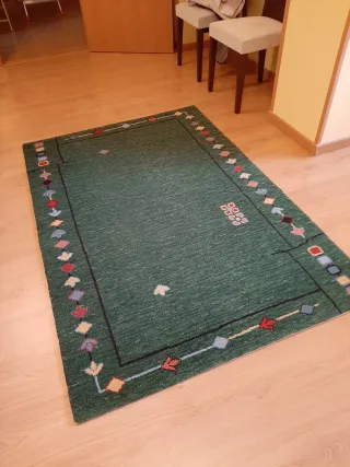 Alfombra de lana verde con diseño multicolor