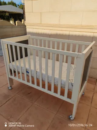 Cuna de bebé blanca con ruedas