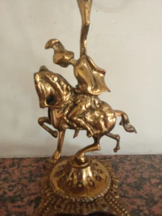 Candelabro antiguo de bronce con jinete a caballo.