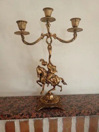 Candelabro antiguo de bronce con jinete a caballo.