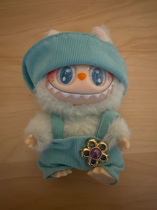 Labubu con mono azul y broche flor
