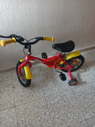 Bicicleta infantil roja con ruedines
