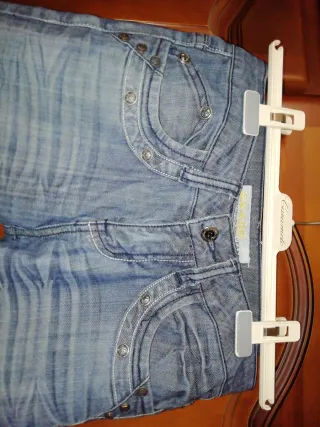Pantalón vaquero desgastado con detalles.