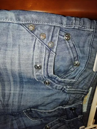 Pantalón vaquero desgastado con detalles.
