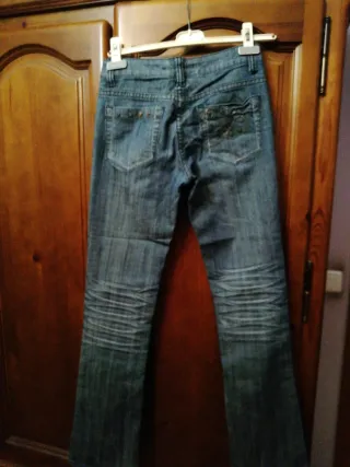 Pantalón vaquero desgastado con detalles.