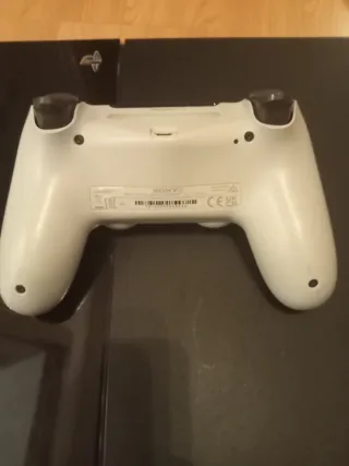 PS4 con mando blanco y cables