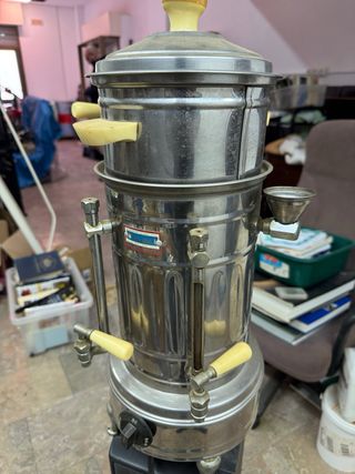 Cafetera antigua de metal con dispensador