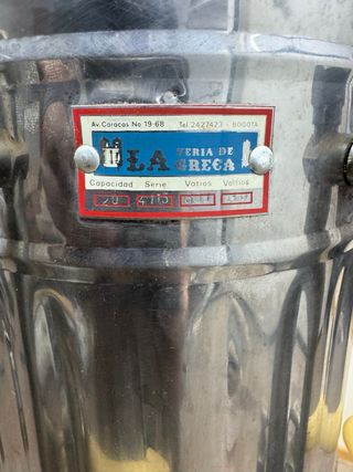 Cafetera antigua de metal con dispensador