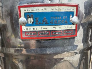 Cafetera antigua de metal con dispensador