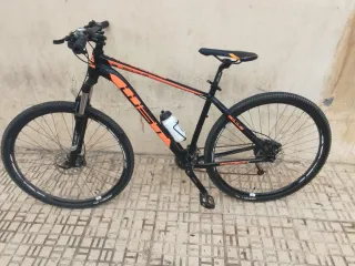 Bicicleta de montaña color negro y naranja.