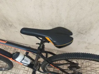 Bicicleta de montaña color negro y naranja.