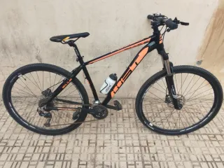 Bicicleta de montaña color negro y naranja.