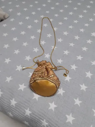 Bolso limosnera dorado con pedrería