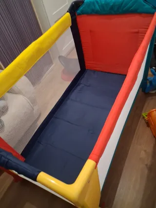 Cuna de viaje colorida usada dos veces