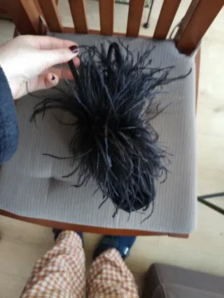 Bolso de mano negro con plumas