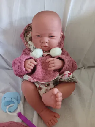 Muñeca bebé recién nacido realista con chupete.