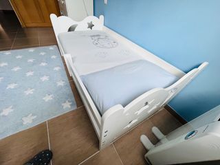 Cama infantil con colchón, ropa de cama y cajón.
