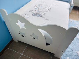 Cama infantil con colchón, ropa de cama y cajón.