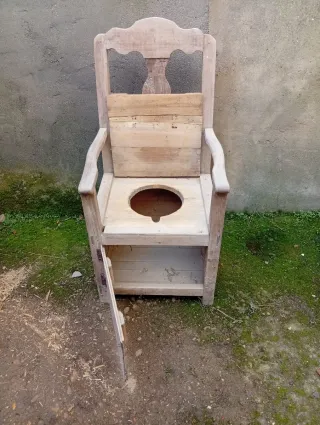 Silla antigua de madera con orinal.