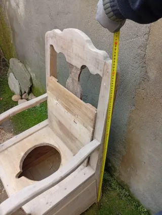 Silla antigua de madera con orinal.