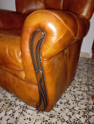 Poltrona in pelle marrone con dettagli in legno