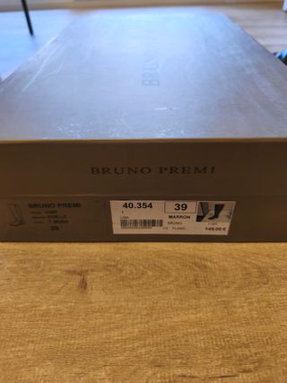 Botas altas de piel marrón oscuro en su caja.