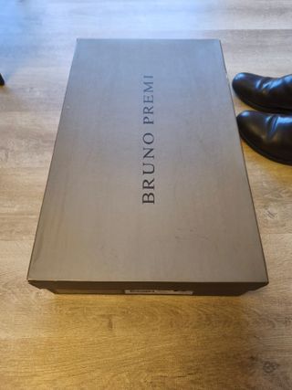 Botas altas de piel marrón oscuro en su caja.