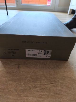 Botas altas de piel marrón oscuro en su caja.