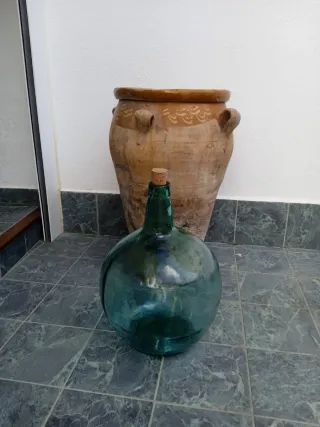 Tinaja olza antigua de barro y garrafa de cristal