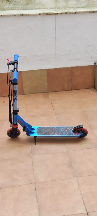 Patinete infantil azul con ruedas rojas